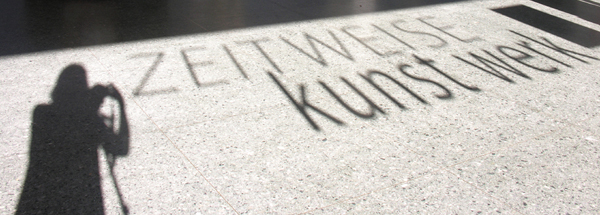 ZW2: Foto von außen in die Projekthalle des Stolzehauses, Silhouette KWS + Projekttitel, Foto KWS